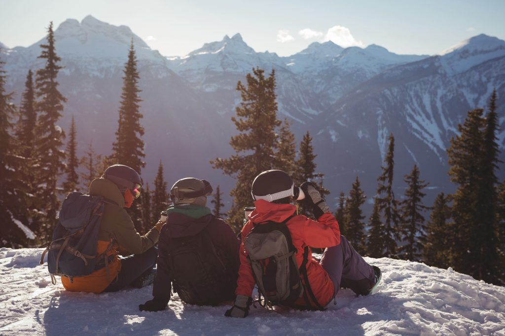 Three skiers relaxing snow covered mountain